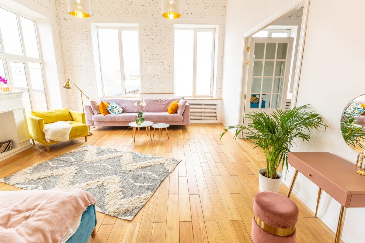 Bright apartment living room with natural light flooding through large windows, creating an open and airy atmosphere perfect for small spaces.