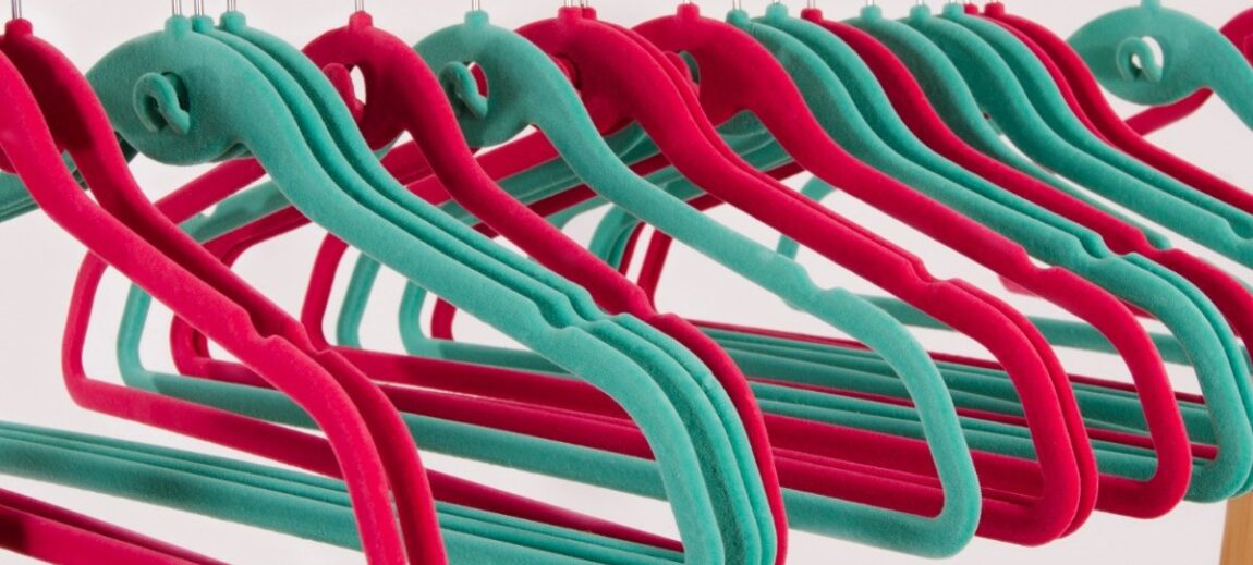 Colorful velvet hangers on a rod.