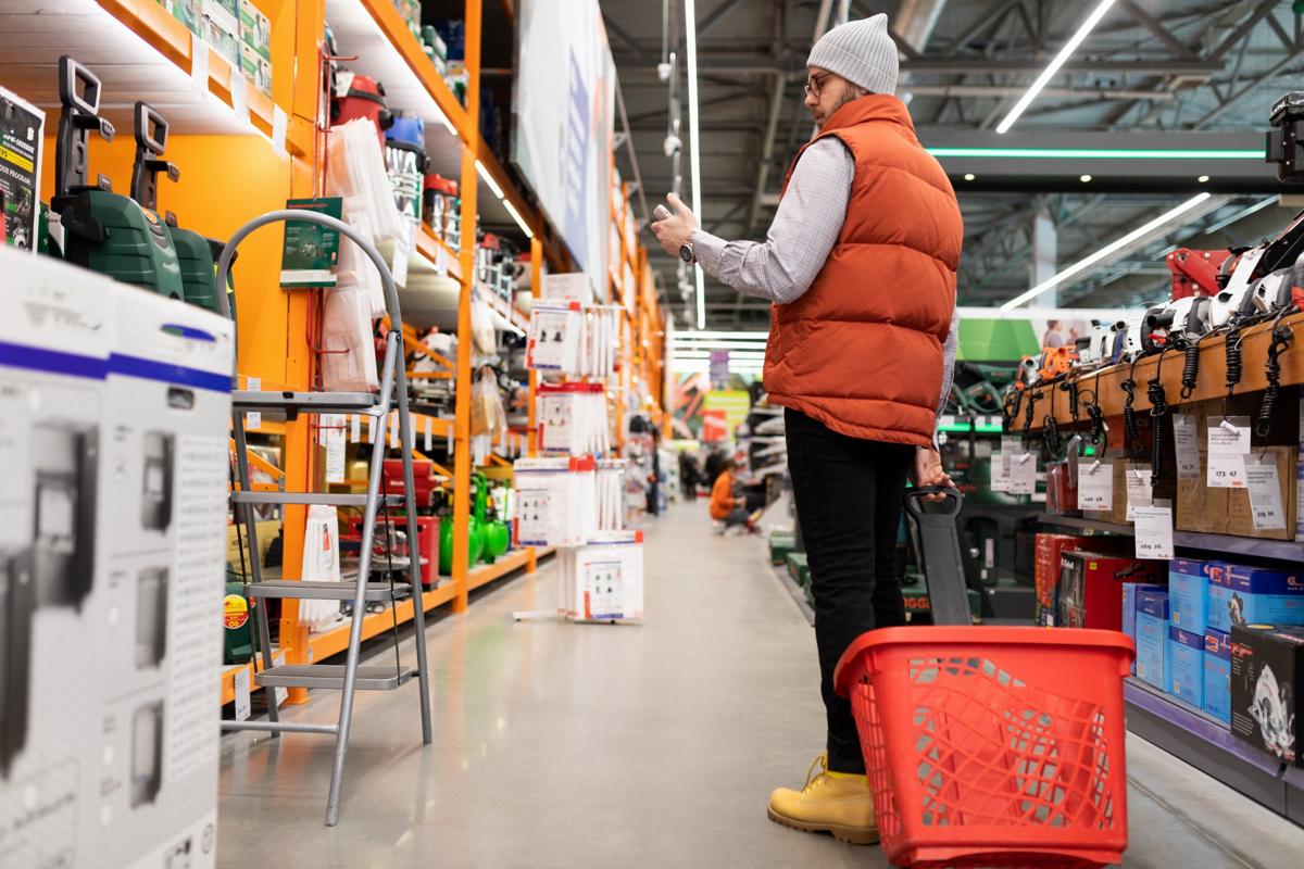 Man shopping for moving boxes and tools in a home improvement store aisle — ideal for apartment moving preparation.
