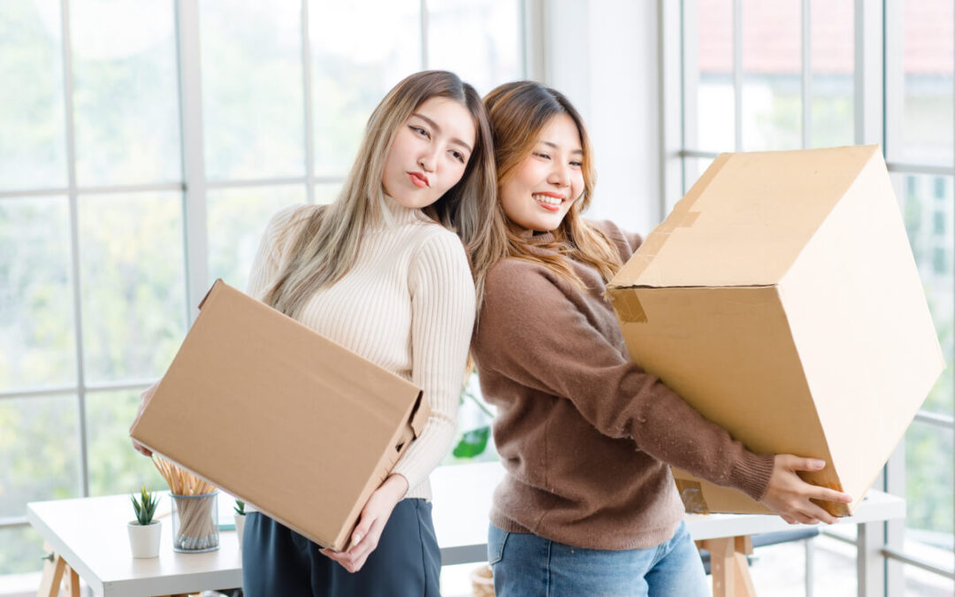 Roommates holding moving boxes