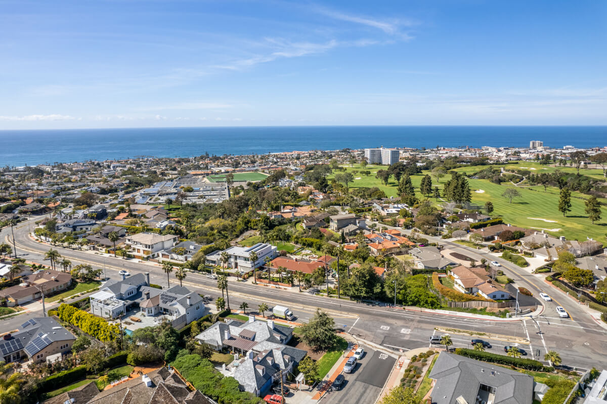 Aerial image of La Jolla with golf courses, ocean views, and upscale homes, appealing to those searching for premium coastal real estate in San Diego.