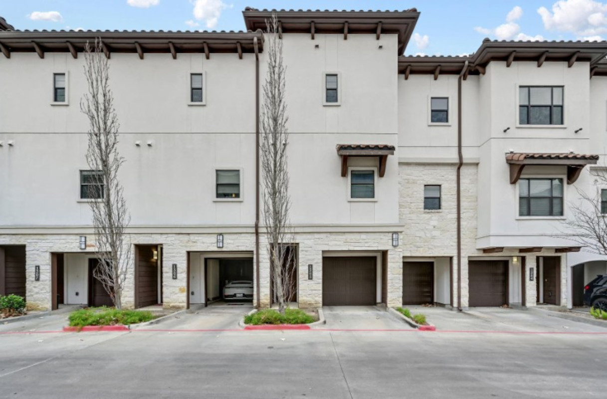 Tall, stucco-colored townhomes with small garages 