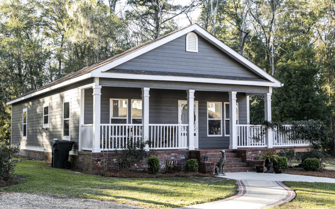 A small gray bungalow on a quiet street.