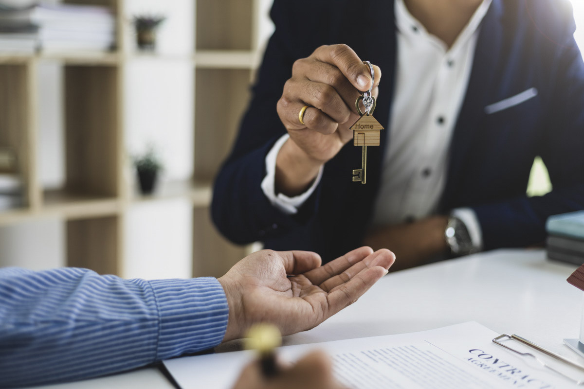 A leasing agent hands keys to a second chance tenant after signing the lease.