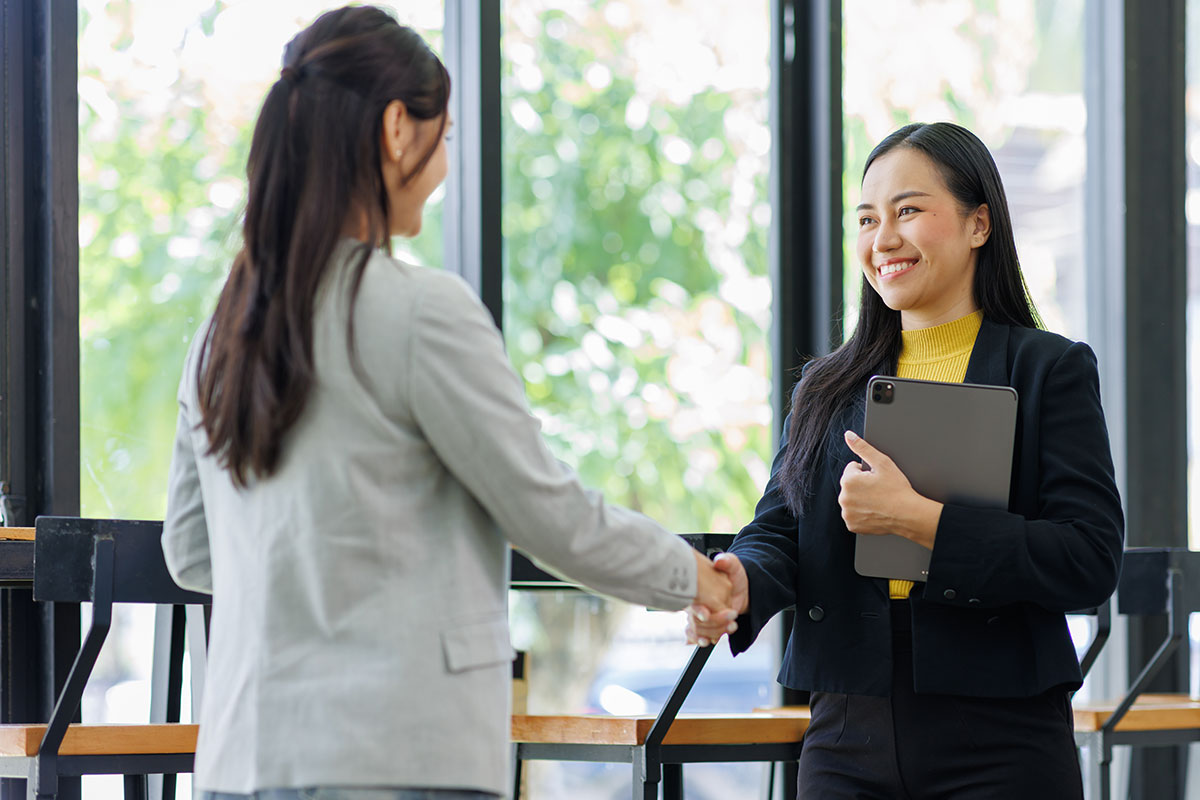 Landlord shaking hands with a renter that just got approved for an apartment.