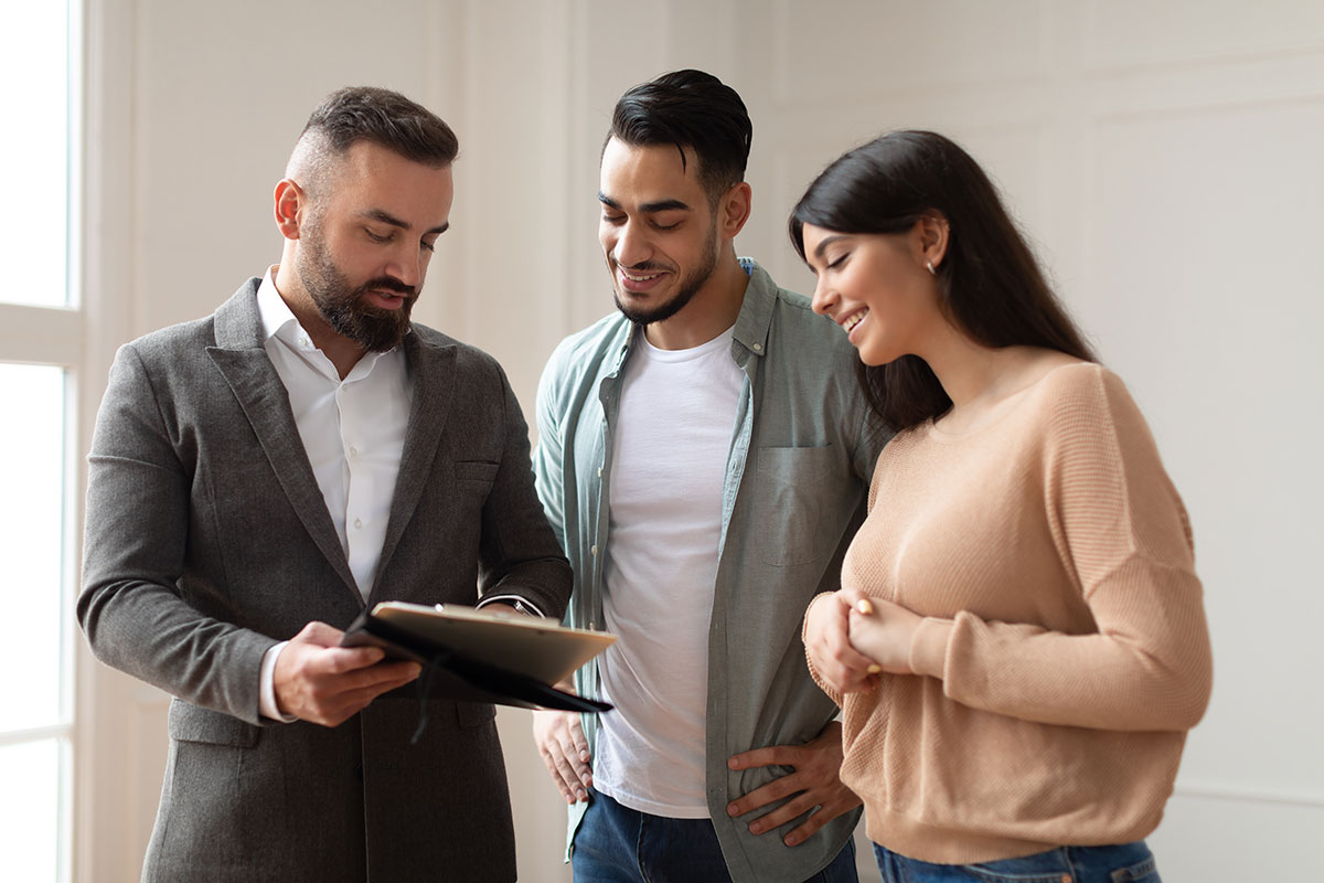 Renters reading over their lease with the leasing agent before signing.